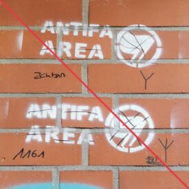 Zwei Graffiti mit dem Schriftzug "Antifa Area", die durchgestrichen wurden, daneben die Schriftzüge "Zcn Bxn", "1161", "141" und zwei Runen, in schwarzem Marker, an einer Mauerwand.