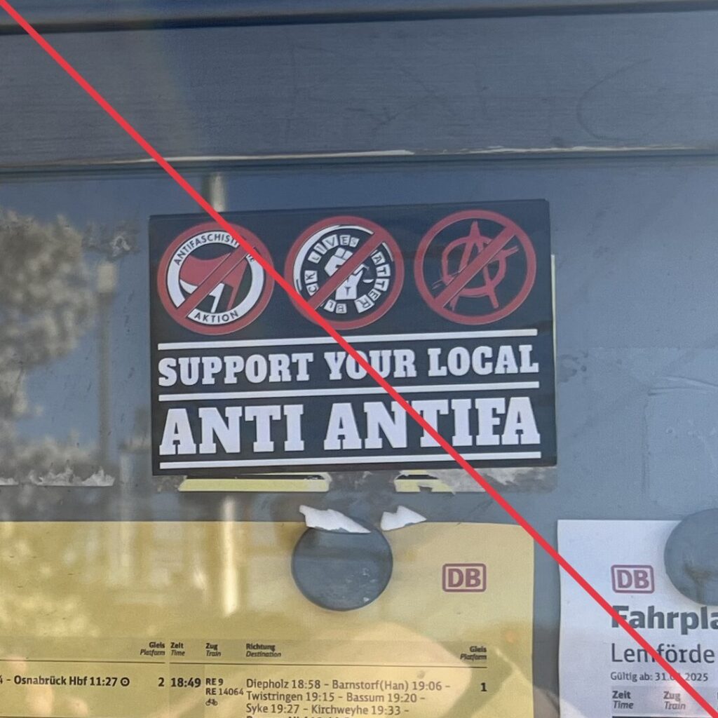 Aufkleber mit Aufschrift "Support your local Anti Antifa" auf der Scheibe einer Informationstafel.