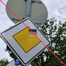 Aufkleber mit Aufschrift "#Stolzmonat" auf einem Vorfahrtsschild.