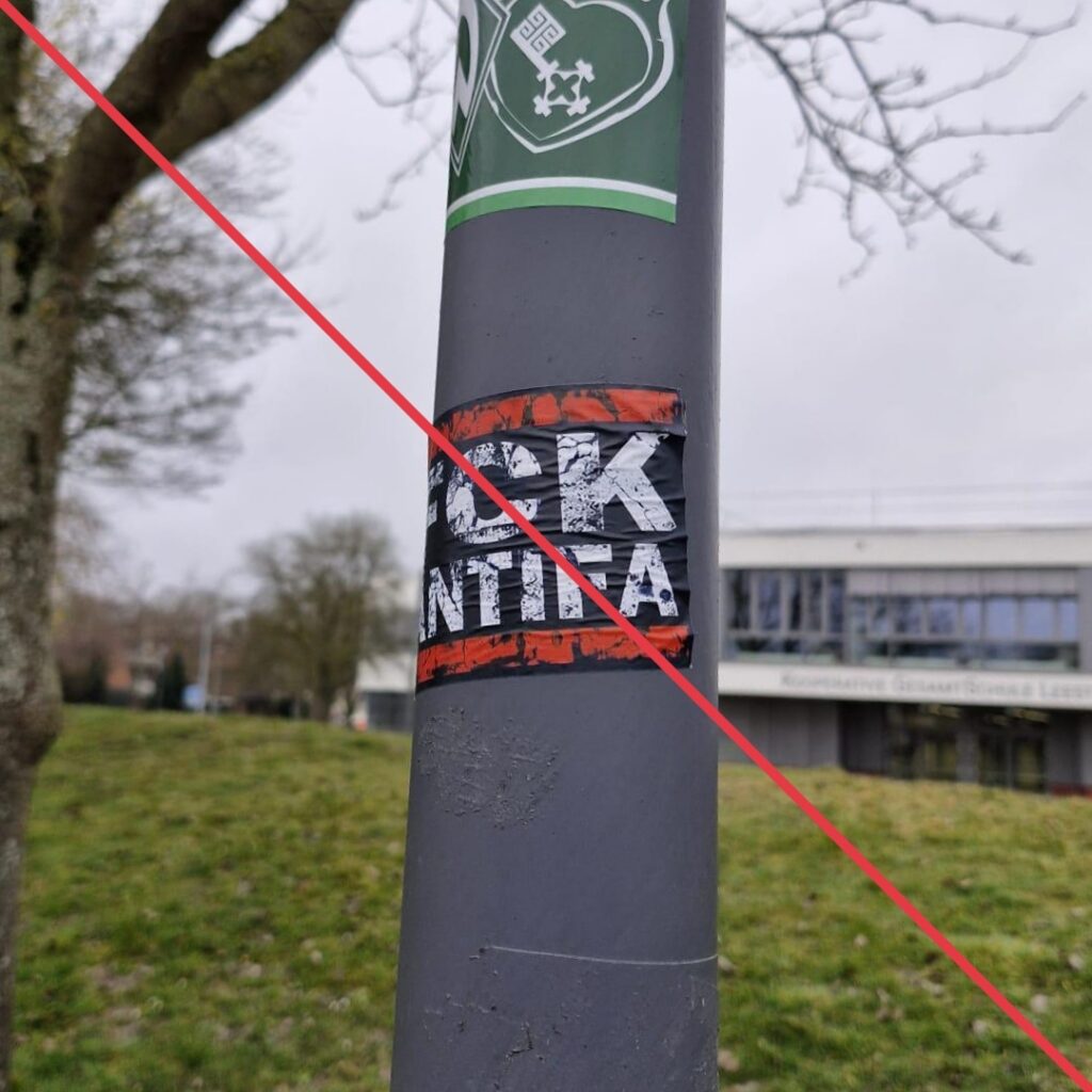 Aufkleber mit Aufschrift "FCK Antifa" auf einem Schildermast.