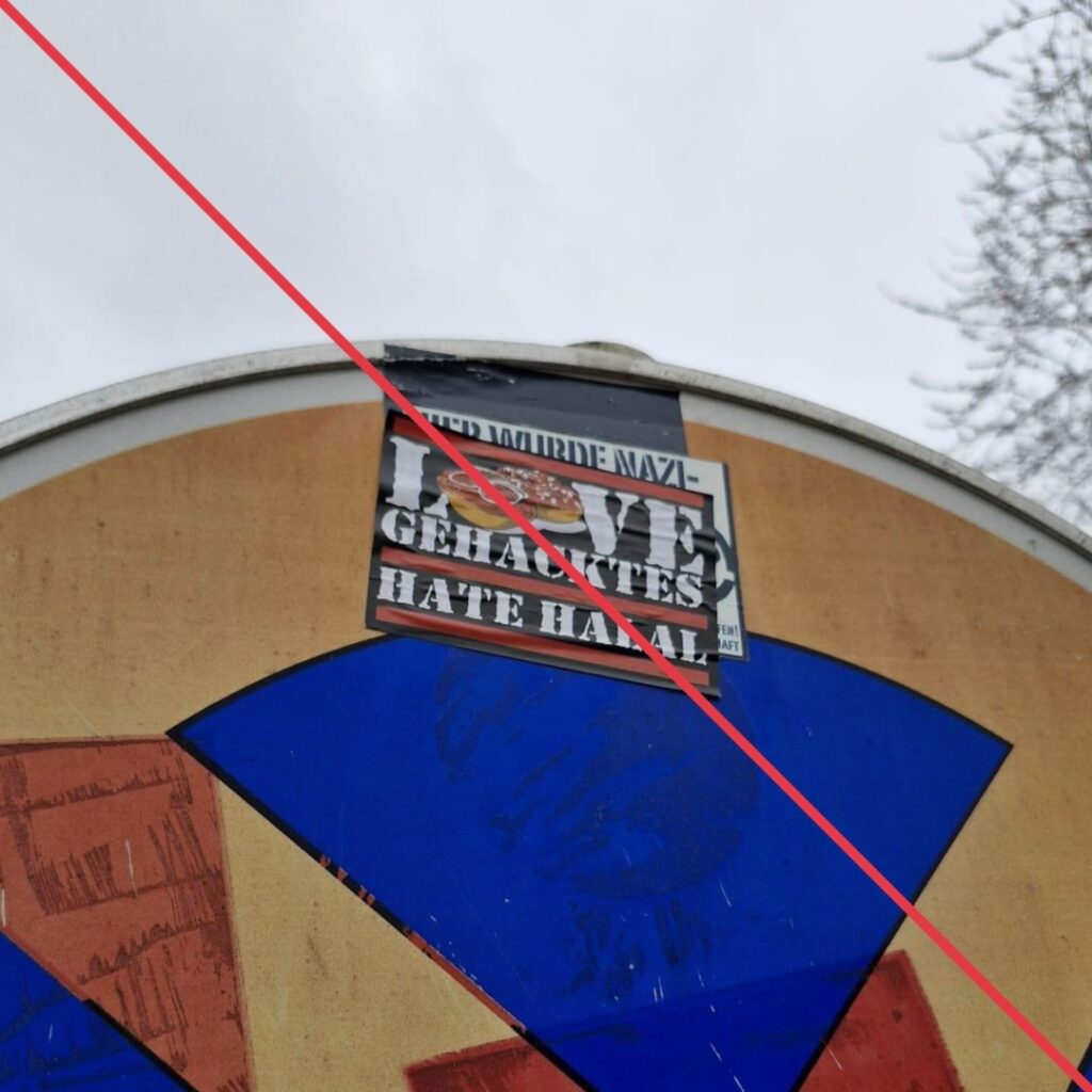 Aufkleber mit Aufschrift "Love Gehacktes, hate Halal" auf einem Parkverbotsschild.